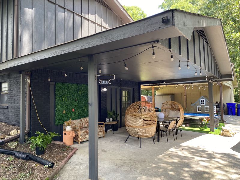 Covered back patio with dark painted board-and-batten siding, posts and ceiling